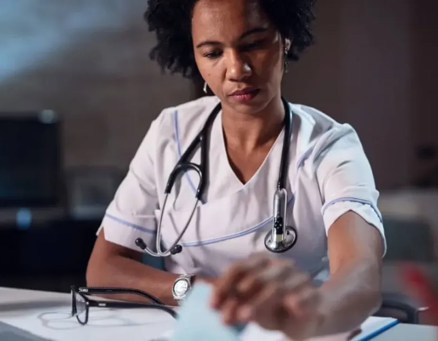 Nurse with associate degree in nursing reviewing documents in office